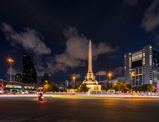 Trails of car lights and the Victory Monument in Bangkok at night