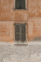 Coral facade wall and wooden window with shutters. Abstract Italian architecture design