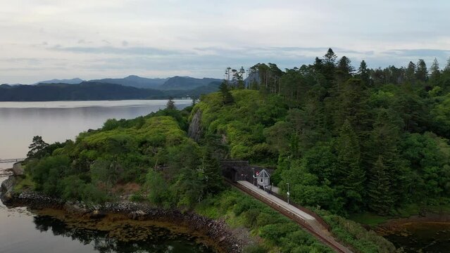 Impressive drone shot of Duncraig Castle, Plockton. The shot sweeps along the train track on the edge of Plockton harbour, and finishes over the castle with Plockton and Skye in the distance.