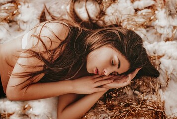 A sleeping girl with long hair lies on a soft cloud with golden tinsel.