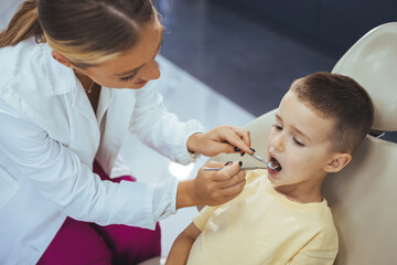 Beautiful boy at the dentist getting a check up on her teeth - pediatrics dental care concepts....