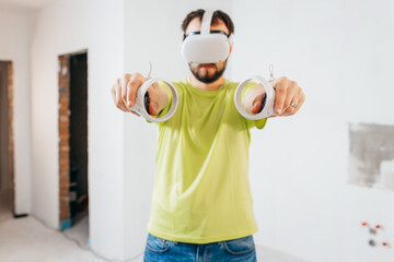 Young bearded man using virtual reality goggles before starting renovations in his townhouse