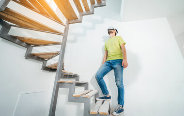 Fototapeta premium Young bearded man using virtual reality goggles before starting renovations in his townhouse