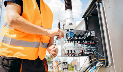 Adult electrical engineer inspect the electrical systems at the equipment control cabinet....