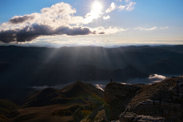 Fototapeta na wymiar A girl meets the sunset over the Caucasus mountains