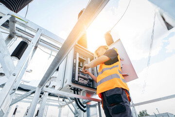 Adult electrical engineer inspect the electrical systems at the equipment control cabinet....
