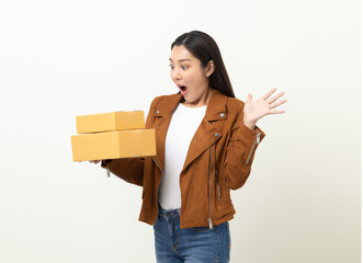 Young excited beautiful asian woman with many parcel cardboard standing on isolated white background. Cheerful female holding lot of parcel box receive from the delivery service