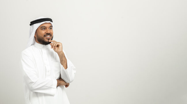 Portrait of arabic man with kandura dress on isolated white background. Arab business people thinking.