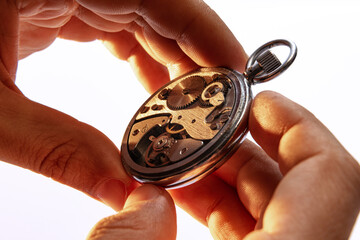 Closeup watchmaker's hands repairing mechanical watches isolated over white background. Concept of vintage retro mechanisms, job, work, ad