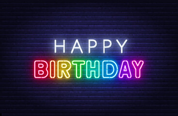 Happy birthday rainbow neon sign on a brick wall.
