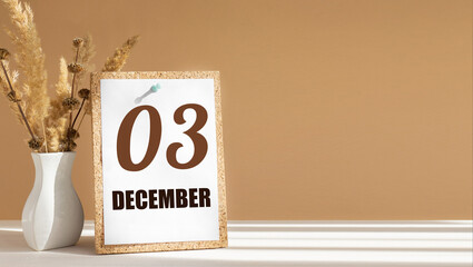 december 3. 3th day of month, calendar date.White vase with dead wood next to cork board with numbers. White-beige background with striped shadow. Concept of day of year, time planner, winter month