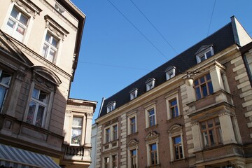 Fototapeta na wymiar Old tenement houses against the sky in a narrow street in Inowrocław.