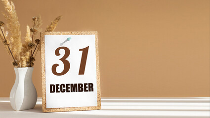 december 31. 31th day of month, calendar date.White vase with dead wood next to cork board with numbers. White-beige background with striped shadow. Concept of day of year, time planner, winter month
