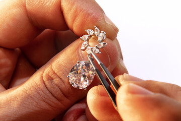 Closeup hands of jeweler at work in jewelry. Desktop for craft jewelry making with professional...