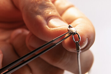 Closeup hands of jeweler at work in jewelry. Desktop for craft jewelry making with professional...