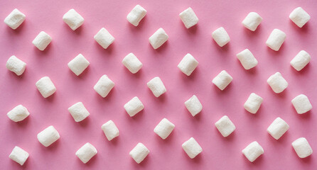 White sweet marshmallows pattern on a solid pink background