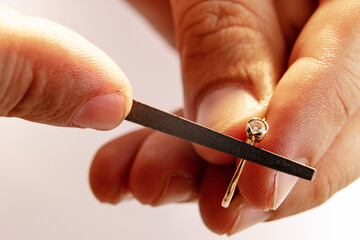 Working process. Closeup hands of jeweler at work in jewelry. Desktop for craft jewelry making with...