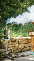 Fototapeta na wymiar steel samovar tea warmer on a garden wall