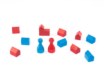 Red and blue houses as wooden figures and two toy figures, as well as a church against a white...