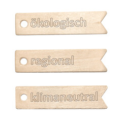 Drei Holzschilder mit der Aufschrift ökologisch, regional, klimaneutral auf weißem Hintergrund