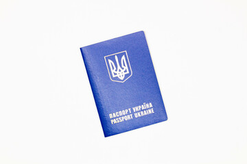 Passport of Ukraine. The cover of the State document of the foreign Ukrainian Passport with the coat of arms of Ukraine in blue on a white background. Image at an angle. Top view. Close-up