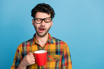 Photo of tired slumber man in eyeglasses wear checkered shirt yawn drink coffee trying to wake up...