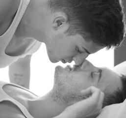 Gay couple relaxing together, LGBT. Two young men kissing and hugging. Black and white portrait. Young men romantic family in love. Happiness concept