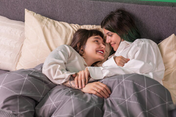 Fototapeta na wymiar Amazing lesbian couple very beautiful ladies enjoy the morning together in bed they touching slowly each other and looking through eyes