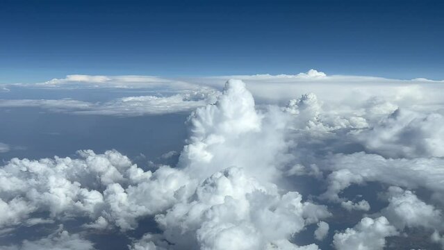Aerial side view from a jet cockpit of a messy sky during cruise level at 12000 metres high. Pilot POV. 4K 60 FPS.