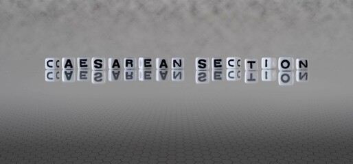 caesarean section word or concept represented by black and white letter cubes on a grey horizon...