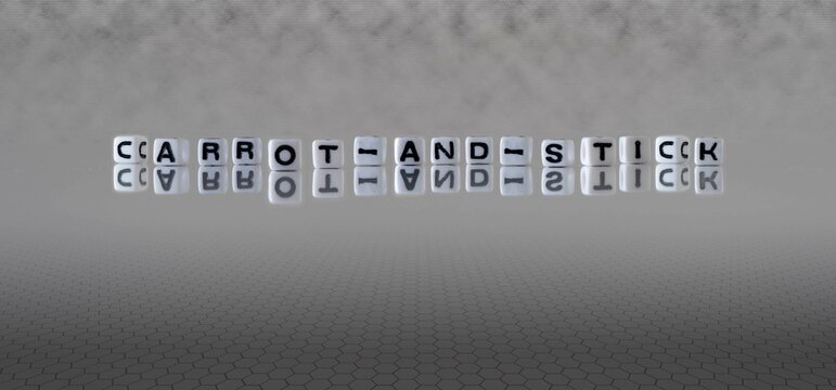 carrot and stick word or concept represented by black and white letter cubes on a grey horizon background stretching to infinity