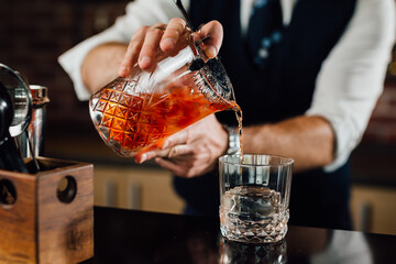 close up of barman pouring drink in glass - obrazy, fototapety, plakaty
