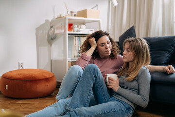 mother talking with her daughter sitting in living room