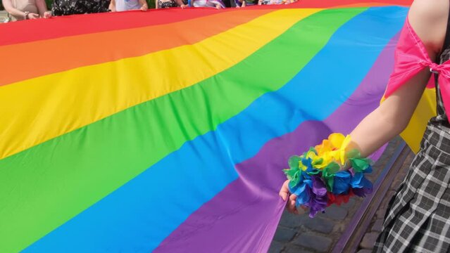 Unidentified person holding huge rainbow flag during LGBT pride