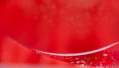 small drops of oil in water on red background. abstract texture 