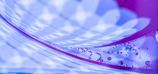 Abstract swirls of blue and purple liquid with oil droplets.  A vibrant, dynamic texture.