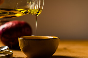 Drips of Oil and Dressing into a glass container in preparation for a salad dressing.