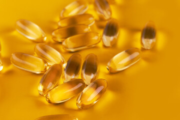 Cod liver oil omega 3 gel capsules, Fish oil capsules with omega 3 and vitamin D on yellow background healthy diet concept