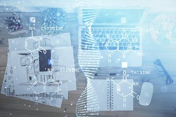 DNA hologram drawings over computer on the desktop background. Top view. Multi exposure. Concept medical education.