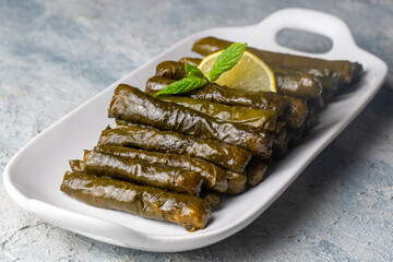 Delicious dolma (sarma) stuffed grape leaves rice. Lebanese dolma sarma on plate. Lebanon turkish greek middle eastern cuisine. (Turkish name; Yaprak sarma)