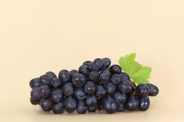 A cluster of red grapes isolated. Cream background.
