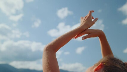 Closeup woman hands cloudy sky. Back view carefree girl raising arms on nature.