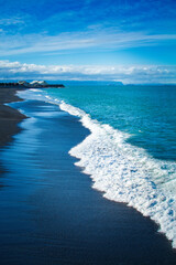 Stunning views of mighty ocean breakers over black sand beach in Napier, New Zealand