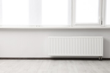 Modern radiator in room, space for text. Central heating system
