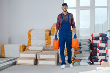 Construction worker carrying canisters in room prepared for renovation