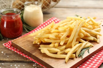 Delicious french fries served on wooden table, closeup