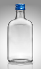 Glass bottle, flask form with alcohol- gin, vodka, or tequila, on light background with reflection.