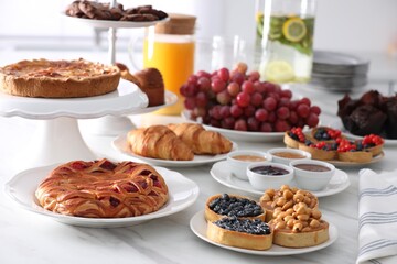 Variety of snacks on white marble table in buffet style indoors