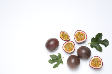 Fresh ripe passion fruits (maracuyas) with leaves on white background, flat lay