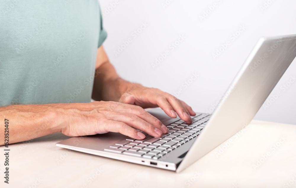 Aufkleber Man hands closeup typing on laptop keyboard. Using computer for work, study. Freelancer lifestyle. Male sitting at desk